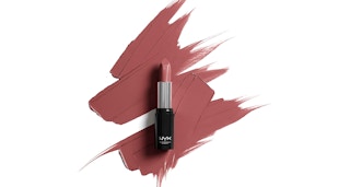 Mauve lipstick smeared on a white background with a lipstick tube on top