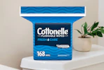 A 168-count pack of Cottonelle Flushable Wipes sits on a toilet tank.