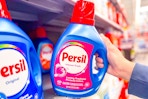 hand grabbing a bottle of Persil laundry detergent