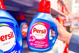 hand grabbing a bottle of Persil laundry detergent