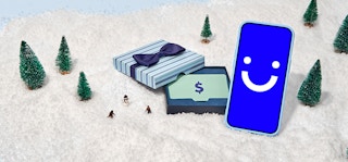 a phone in a winter scene next to a gift card in a box