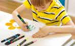 a kid coloring with acrylic makers at a table