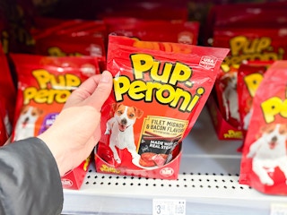 hand grabbing a package of Pupperoni dog treats