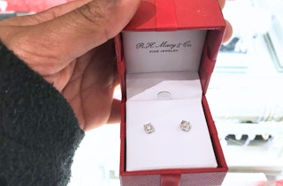 someone holding diamond earrings