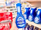 hand holding a dawn powerwash dish spray in front of a parked target cart