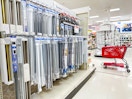 curtain rods sitting on a shelf with a target cart parked in front