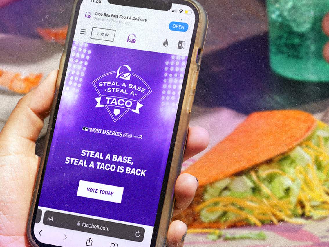 person holding a phone showing the taco bell steal a base, steal a taco campaign for the world series