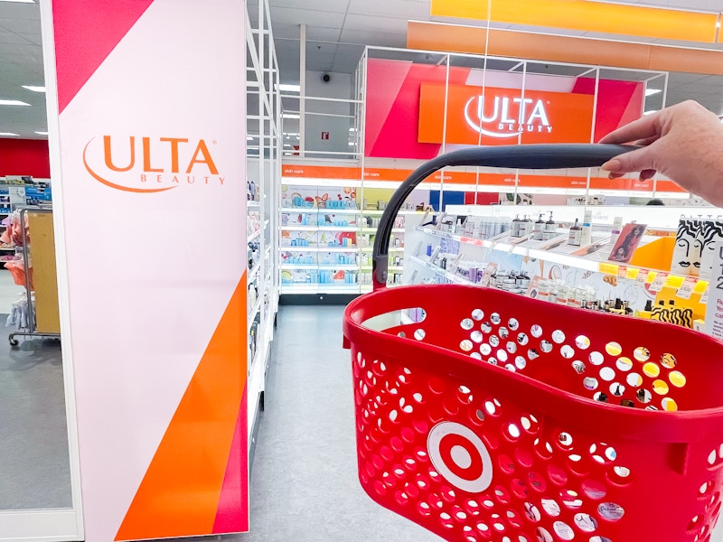 a target hand basket being held in front of ulta sign in the ulta section inside target