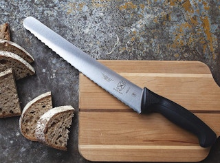 bread knife with bread slices on a cutting board