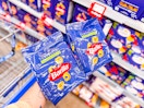 hand holding two bags of barilla tortellini pasta in walmart aisle