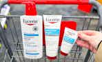 hand grabbing eucerin lotion products in a shopping cart