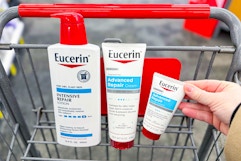 hand grabbing eucerin lotion products in a shopping cart