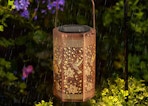 a hummingbird solar lantern on a tree in the rain