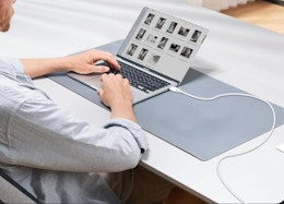 a person charging a laptop at a table
