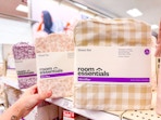 hand grabbing a sheet set sitting on a target shelf