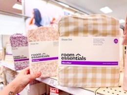 hand grabbing a sheet set sitting on a target shelf