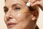 woman applying serum to face