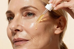 woman applying serum to face