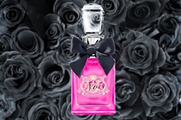 Juicy Couture Perfume in a pink bottle with black roses in the background