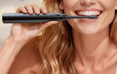 a person using an electric toothbrush