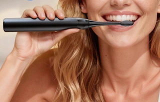 a person using an electric toothbrush