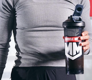 a person holding a protein shake in a shaker bottle