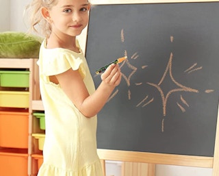 a girl drawing with a chalk mark on a chalkboard