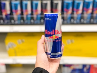 hand holding can of red bull in front of Target store shelf