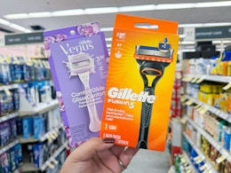 hand holding gillette and venus razors in walgreens