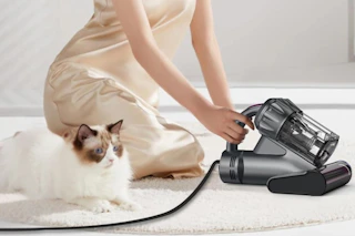 a woman using a mattress vacuum