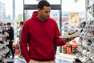 a man wearing a hanes hoodie in a shoe store