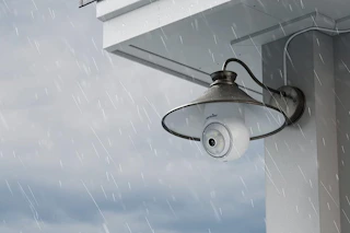 a light bulb camera on the side of a house outside 