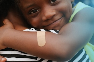 A child wearing a Band-Aid during a hug