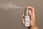 a woman spraying kitsch dry shampoo