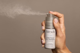 a woman spraying kitsch dry shampoo