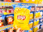hand holding a bag of lays chips