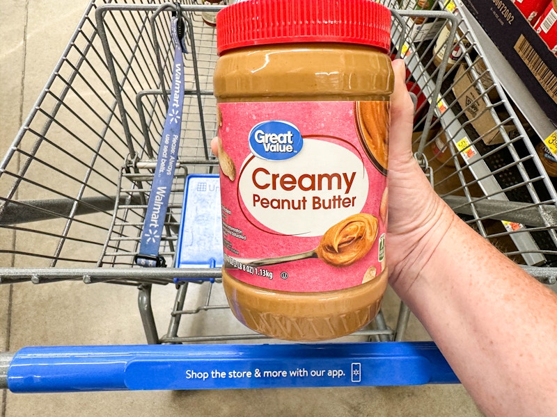 a jar of peanut butter being held in store