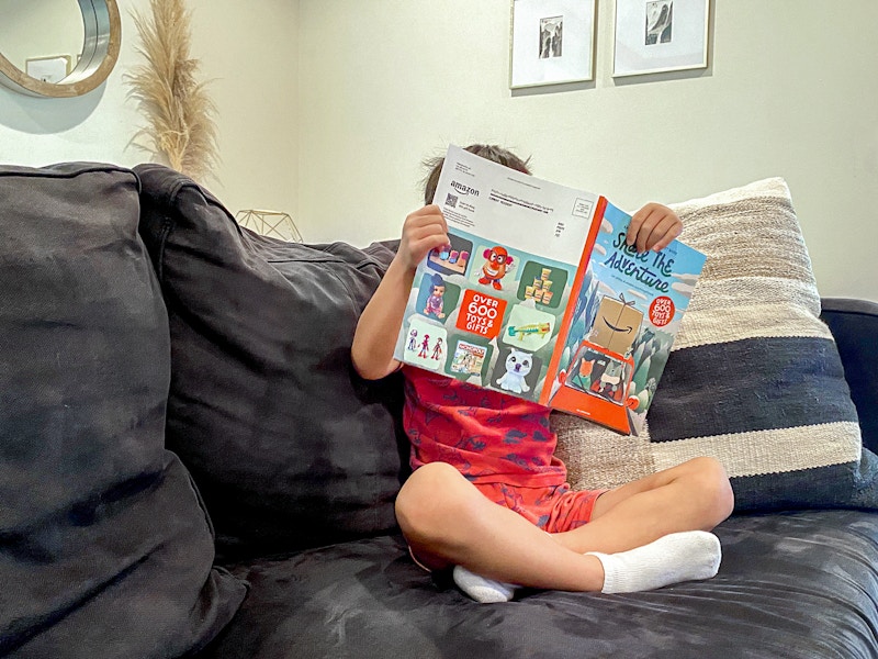 a boy looking at the Amazon toy catalog