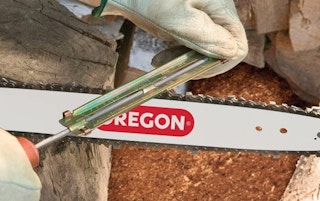 a hand sharpening a chainsaw blade