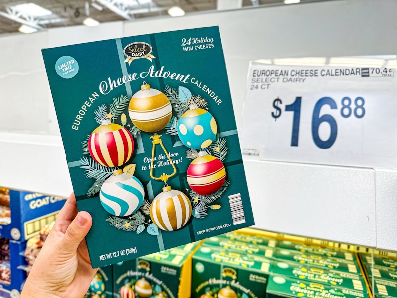 person holding a european cheese advent calendar by a $16.88 price sign