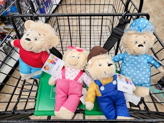 four berenstain bear character plushes in a cart
