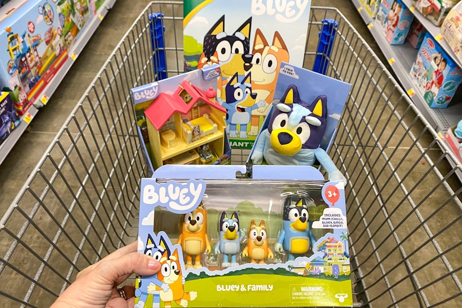 hand holding bluey toy with more bluey toys in walmart cart