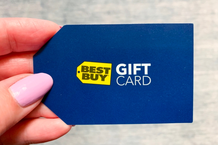 A person holding a Best Buy gift card.