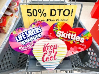 shopping cart with 50% off clearance signage, lifesavers heart box, Skittles heart box, and a chocolate heart box