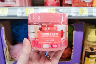 hand holding a jar of scent happy body scrub at dollar general