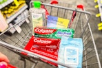 person pushing a cart with colgate toothpaste, beauty360 and creme shop products