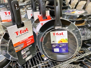 t-fal frying pan sets lined up on a rack in macys