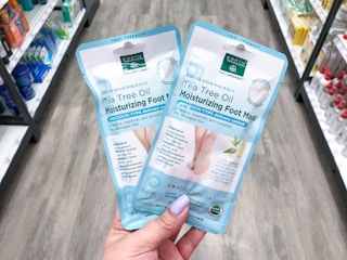 hand holding two earth therapeutics foot masks at target