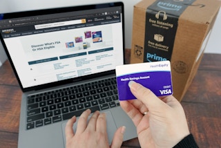 Someone holding a Health Savings Account card and looking at the HSA eligible items on Amazon