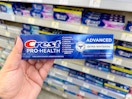hand holding crest toothpaste in walgreens